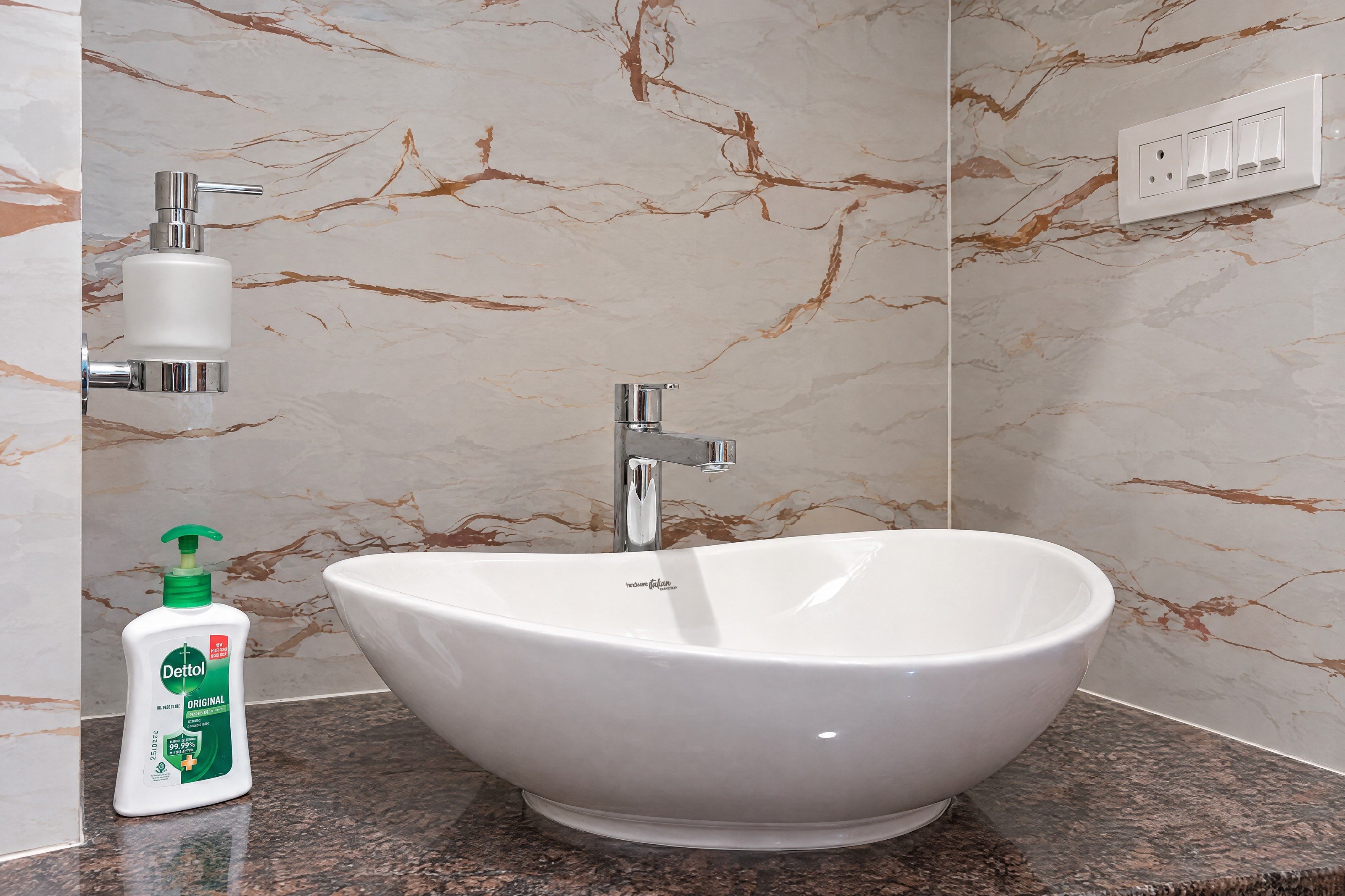 An AI re-angle of a basin, level and square-on: basin, mixer, dispenser and bottle in place, with the basin’s real Hindware logo restored from the original photograph.
